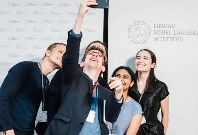 Image of partcipants from France for the Lindau meeting lining up and smiling to pose for a selfie taken by a French ambassador.